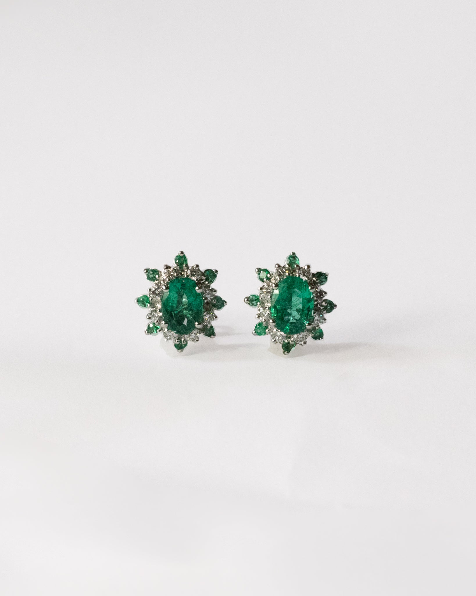 Pair of emerald green earrings on a white background