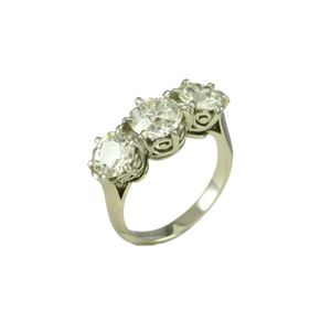 An Edwardian platinum ring claw set with three old European cut diamonds.
