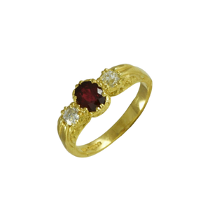 An 18ct. yellow gold ring with a central oval ruby and two old cut diamonds set to either side.